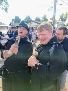 Fr. Charles and Br. Gabriel holding ferrets at the Oktoberfest